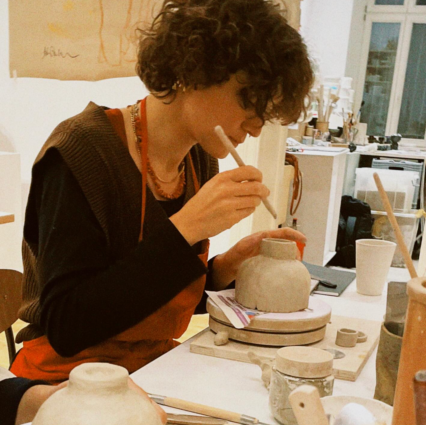 Person working on pottery in a studio setting