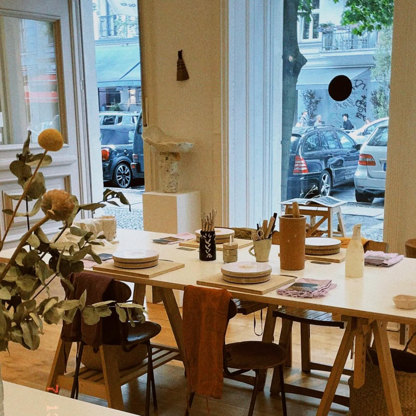 Dining area with a table set for a meal, chairs, and decor elements.