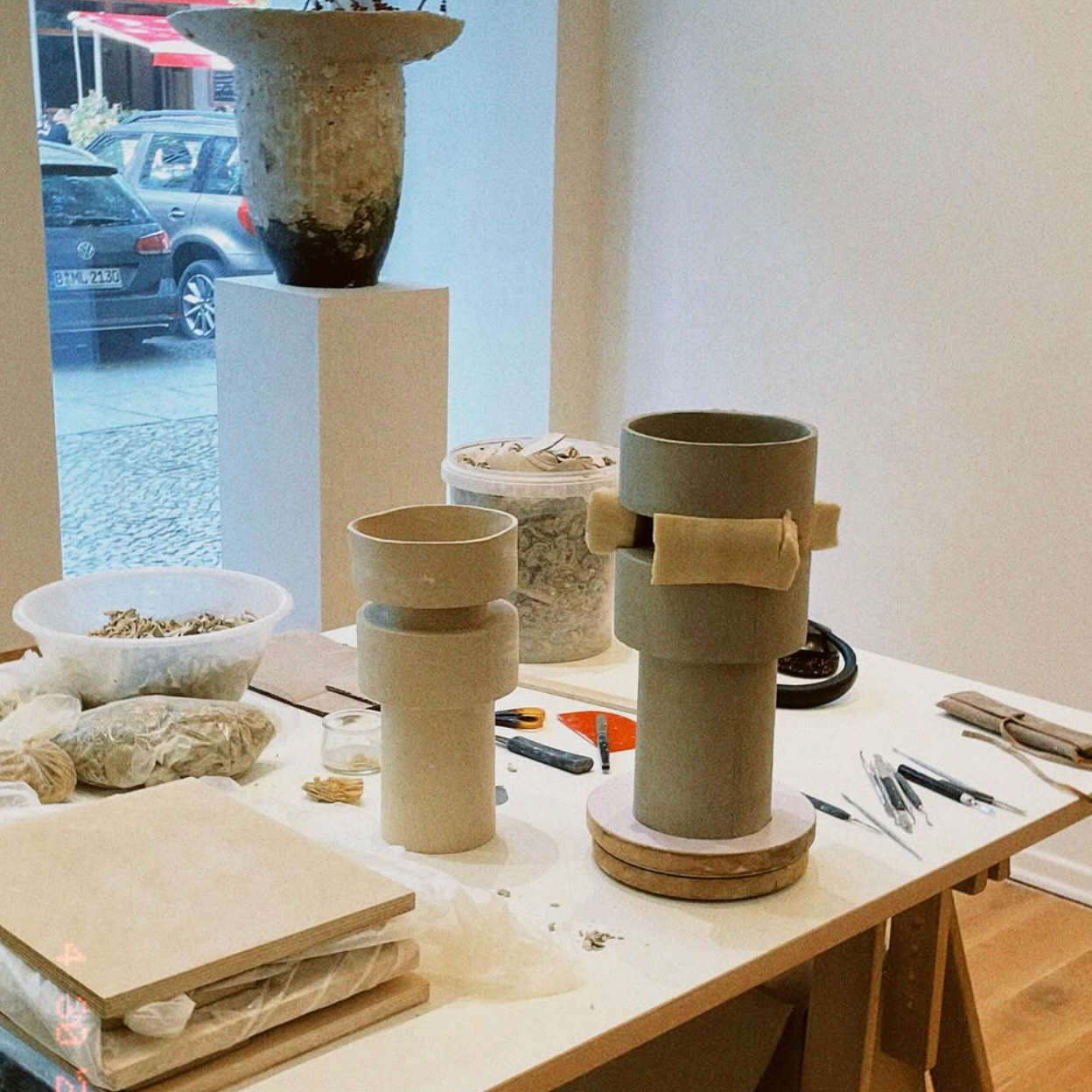 Worktable with ceramic vases and tools in a workshop setting
