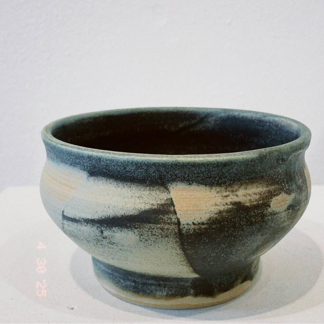 Ceramic bowl with blue and black glaze on a white background