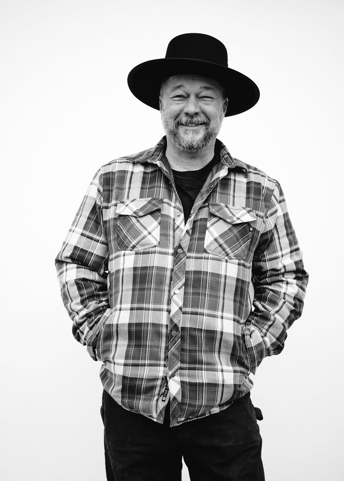 Man wearing a plaid shirt and hat on a white background