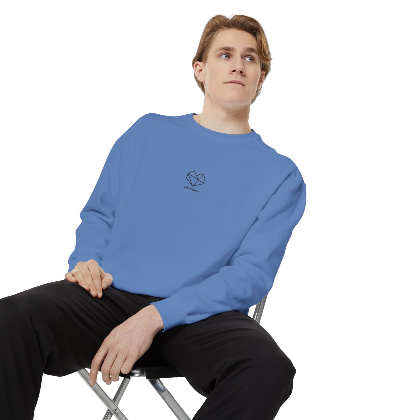 Person wearing a blue sweatshirt with a logo sitting on a chair against a white background