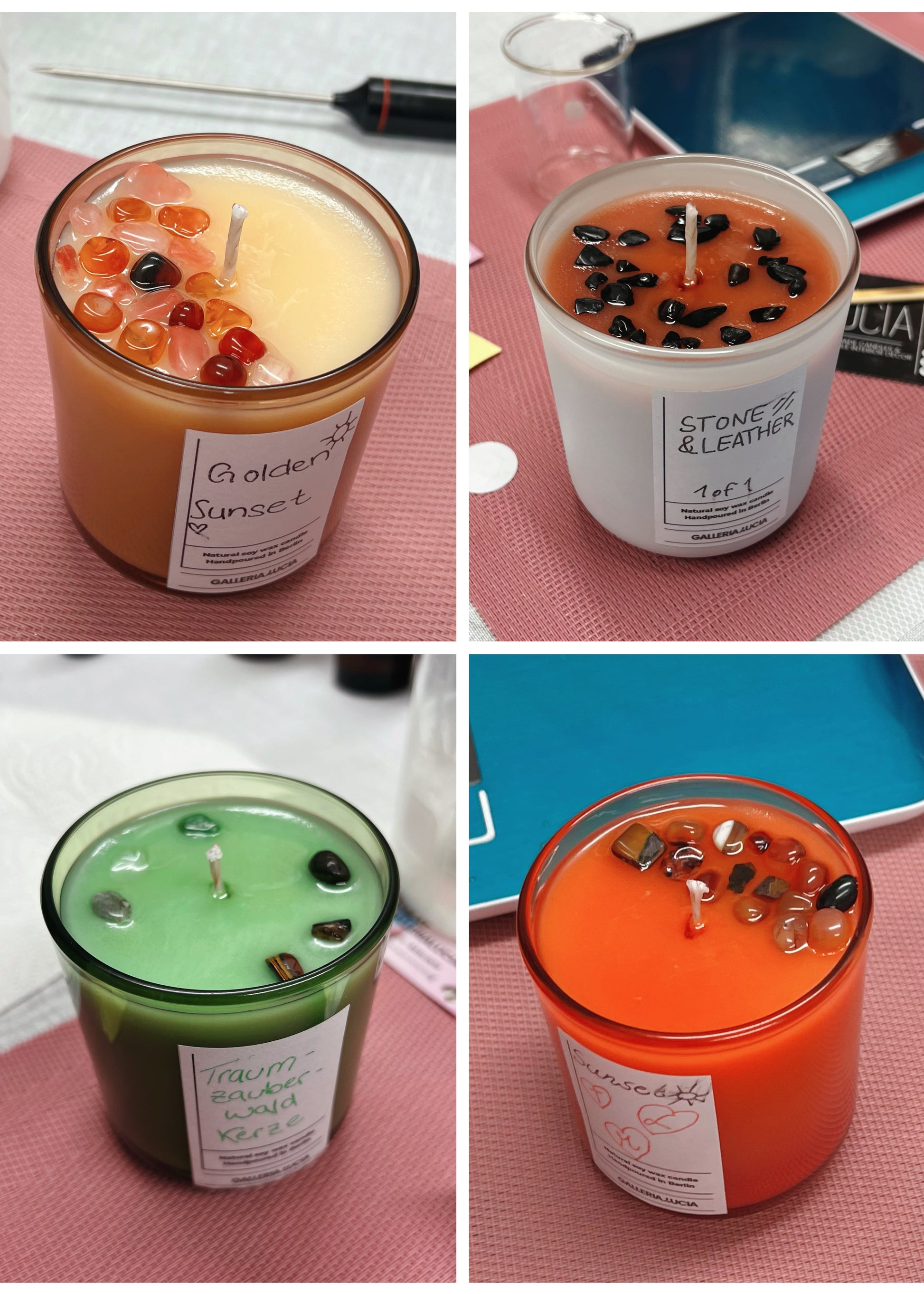 Four different scented candles with visible labels on a pink surface.