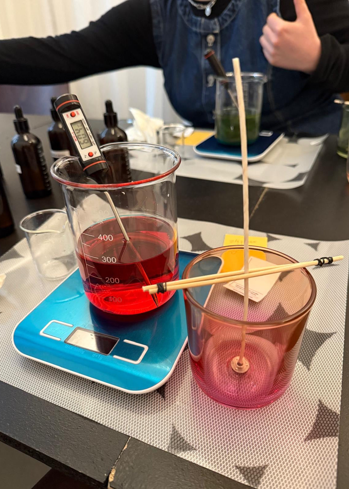 Science experiment setup with beakers, liquid, and a digital scale on a table.