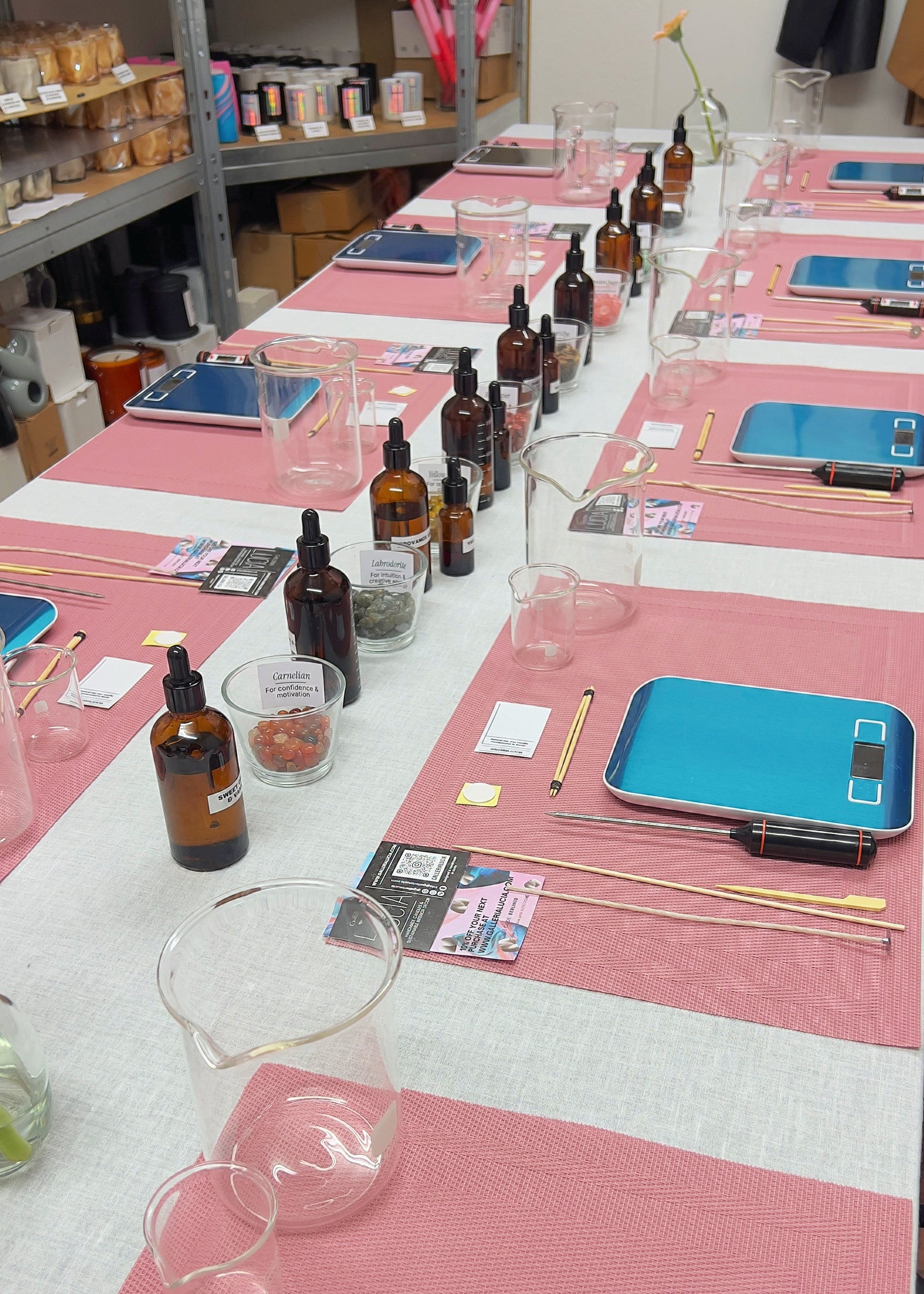 Table setup with bottles, tools, and electronic devices in a workshop or lab setting.