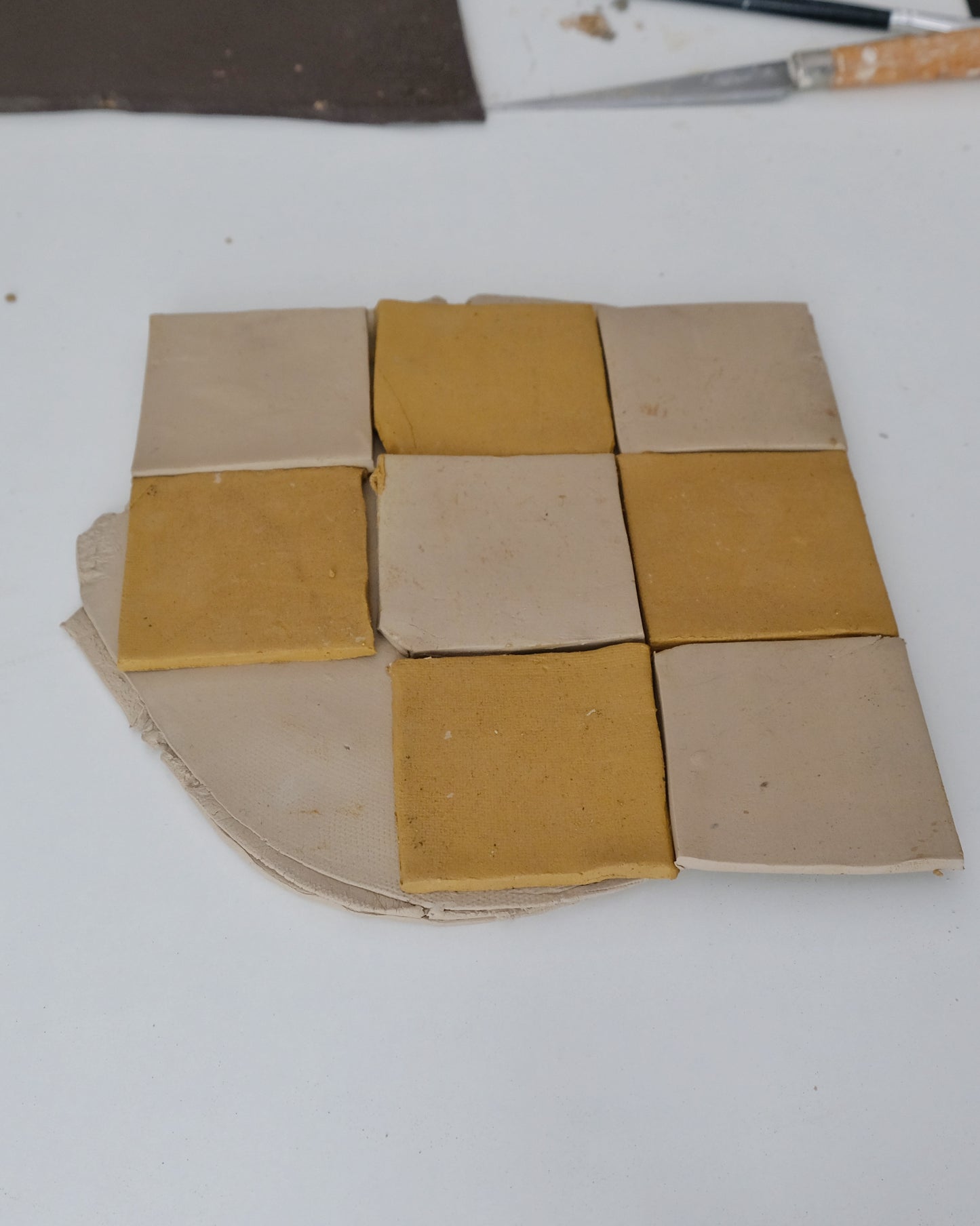 Square tiles arranged in a grid pattern on a white surface