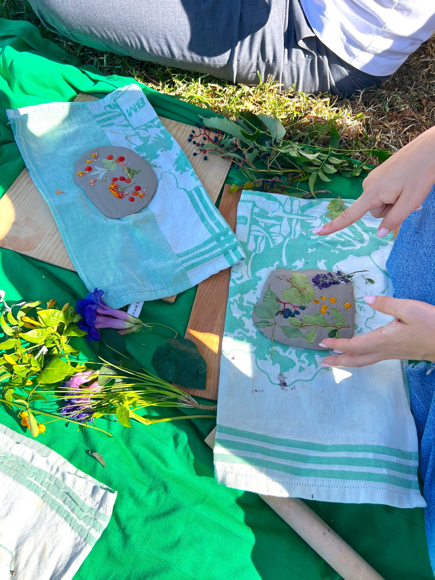 Person holding a fabric with nature-themed design on grass