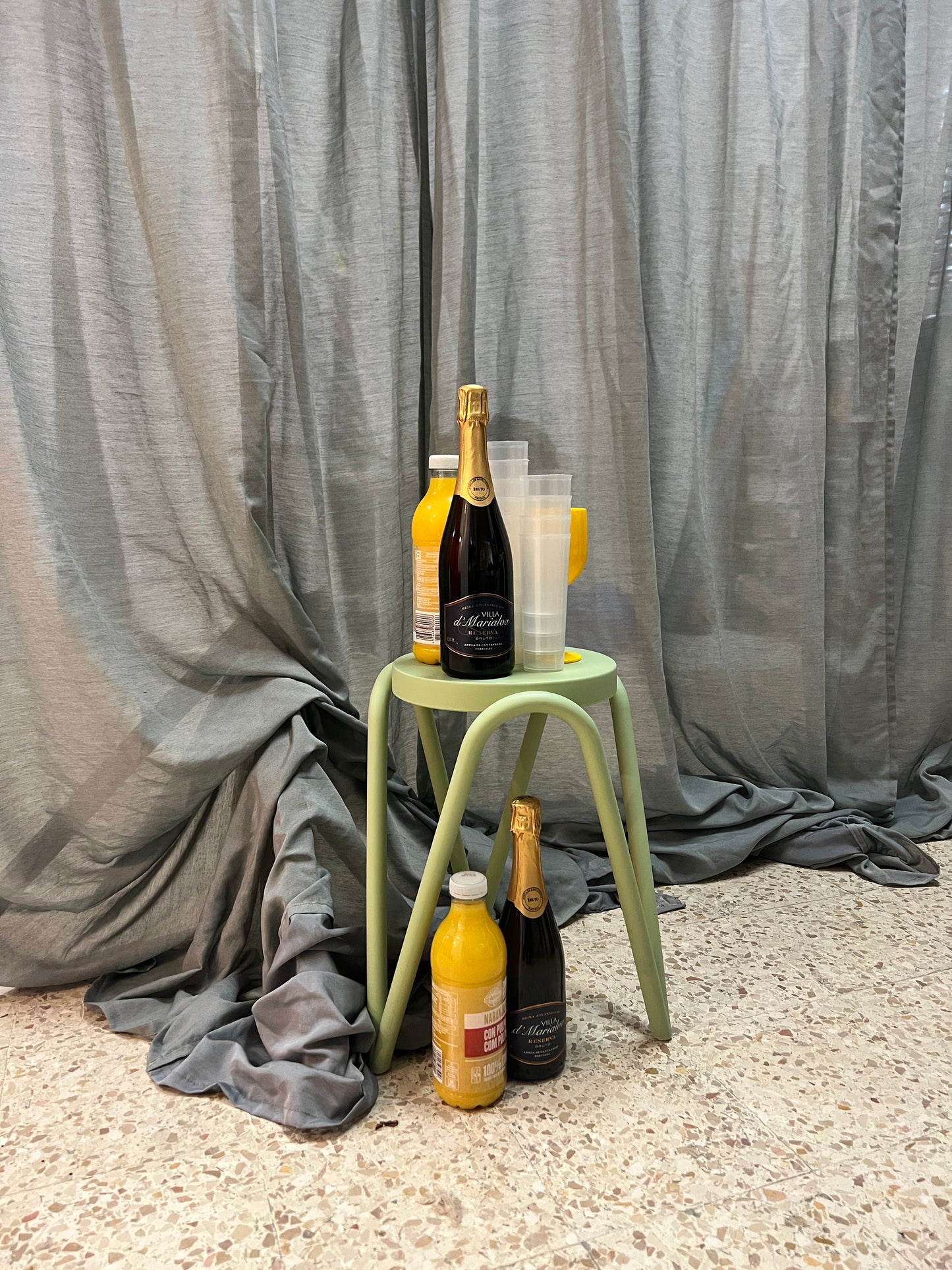 Wine bottles on a stand with a gray blanket and carpet background