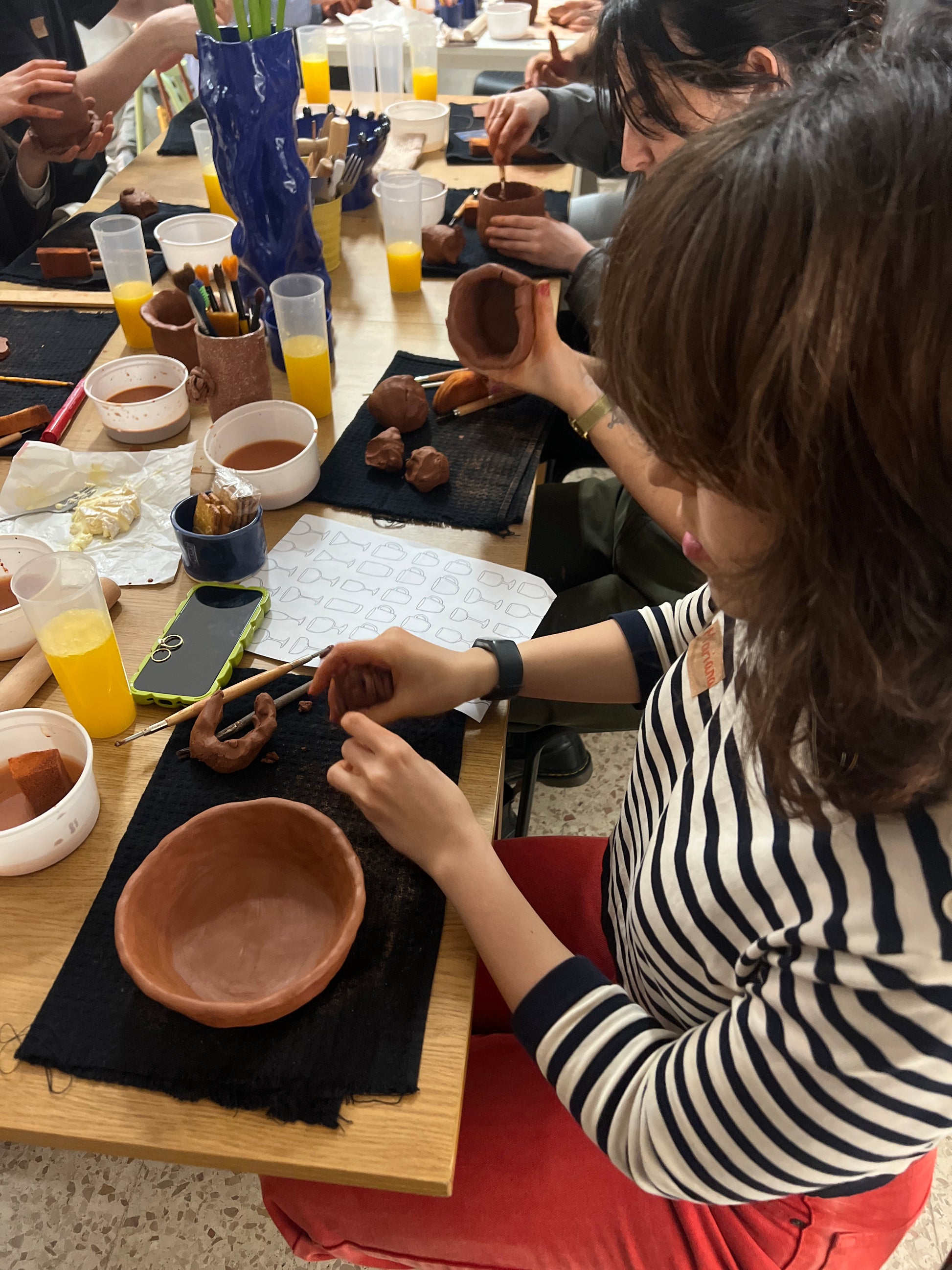 Two people working with clay at a pottery studio.