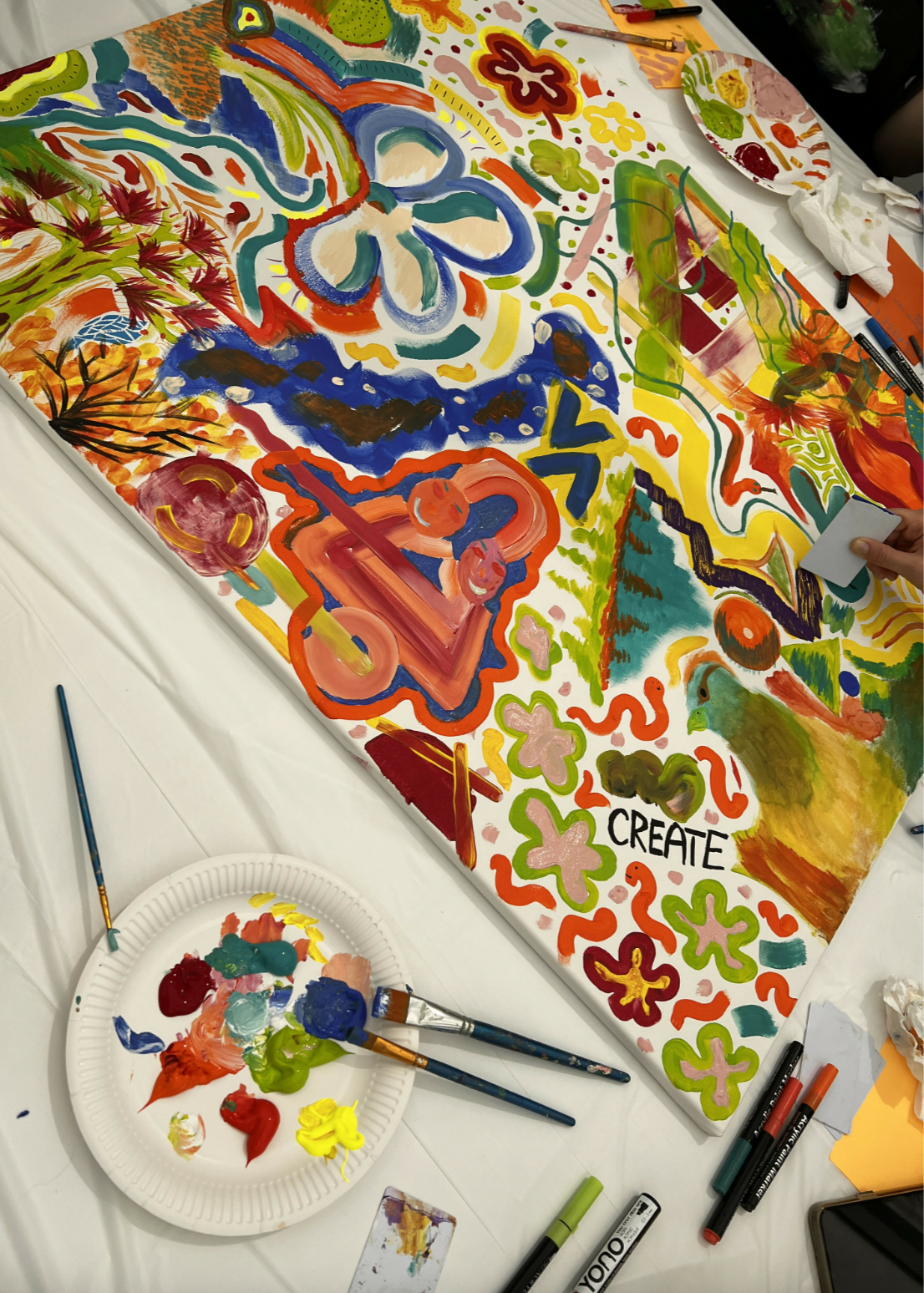 Colorful abstract painting on a table with art supplies