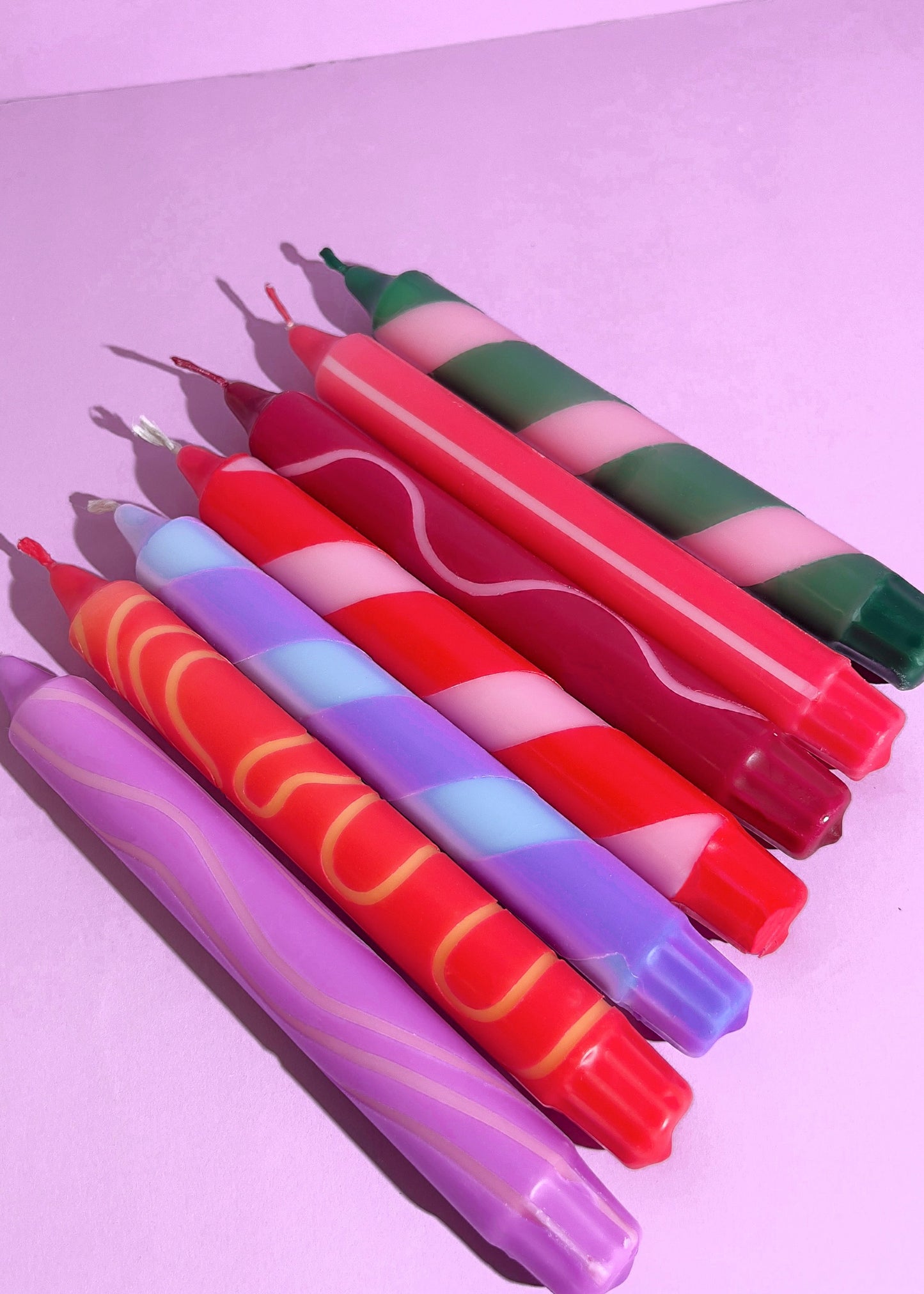 Colorful crayons with wavy patterns on a light purple background