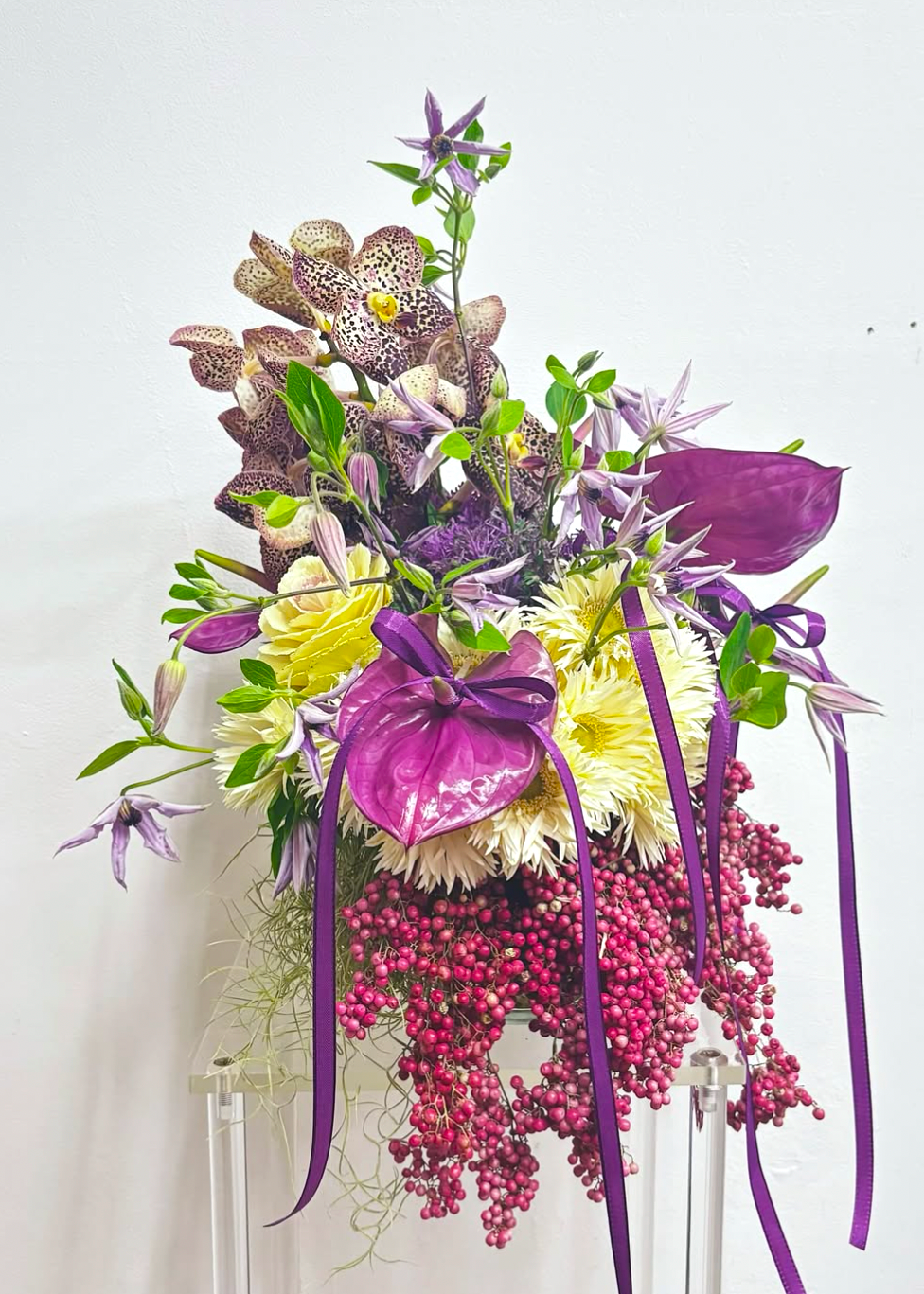 Colorful floral arrangement with purple and yellow flowers on a white background