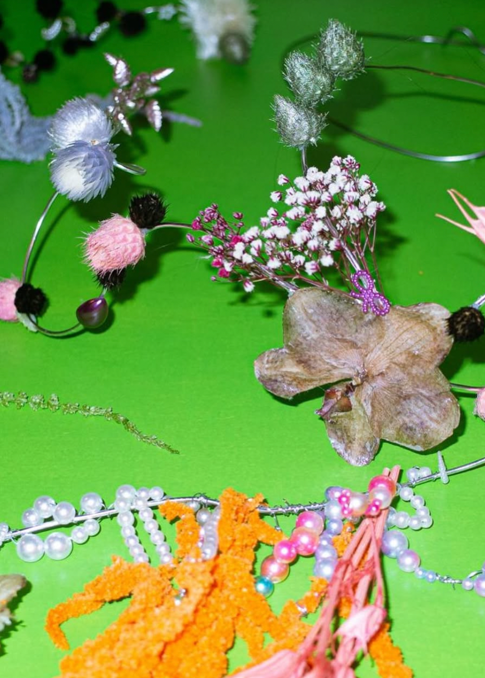 Decorative floral and bead headbands on a green background