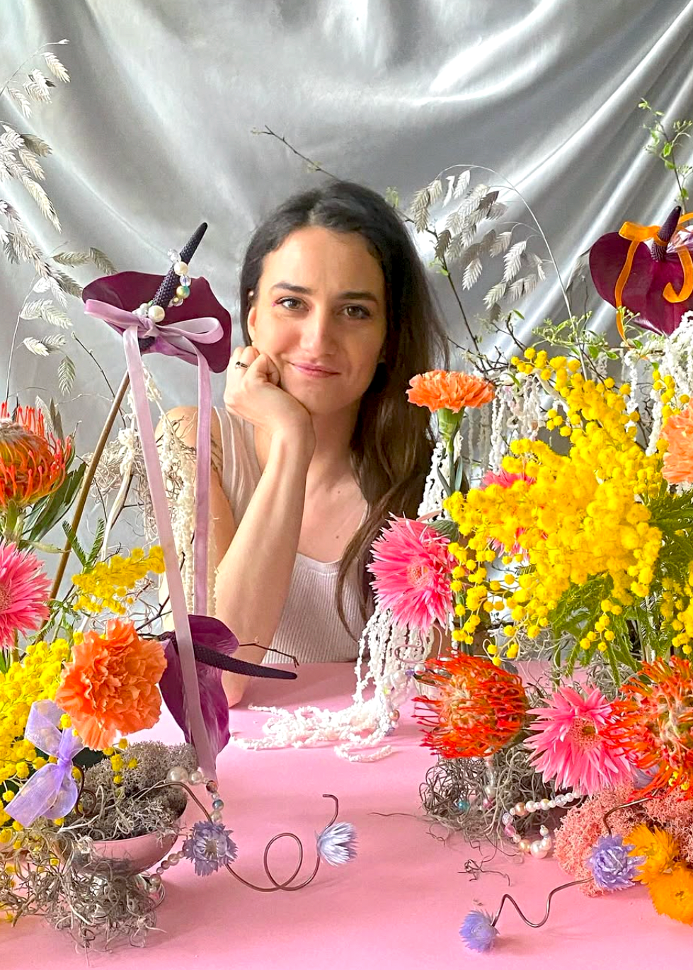 Woman sitting among colorful flowers with a decorative number 75 on a silver background