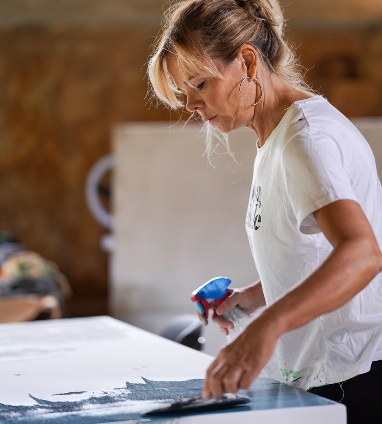 Woman cleaning a surface with a spray bottle and cloth