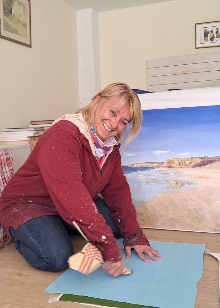 Woman in a room with large prints of nature scenes on the wall.