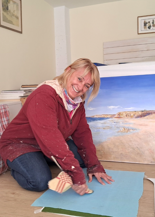 Woman in a room with large prints of nature scenes on the wall.