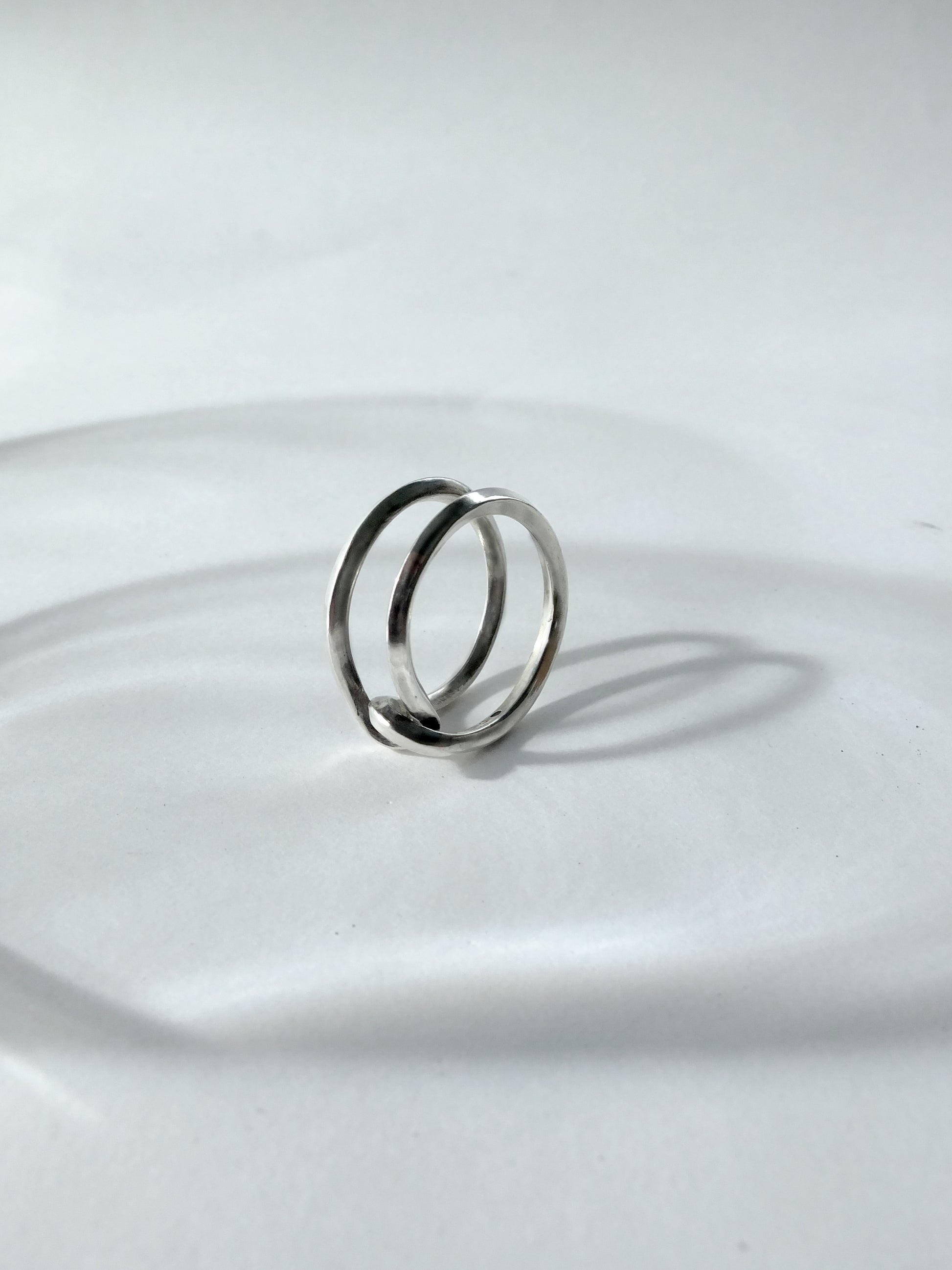 Silver ring on a reflective white surface