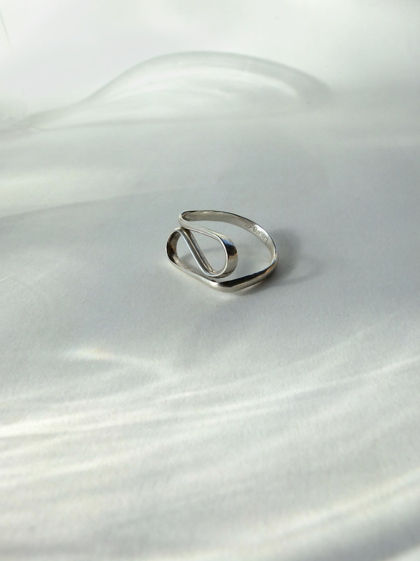 Silver ring on a white fabric background