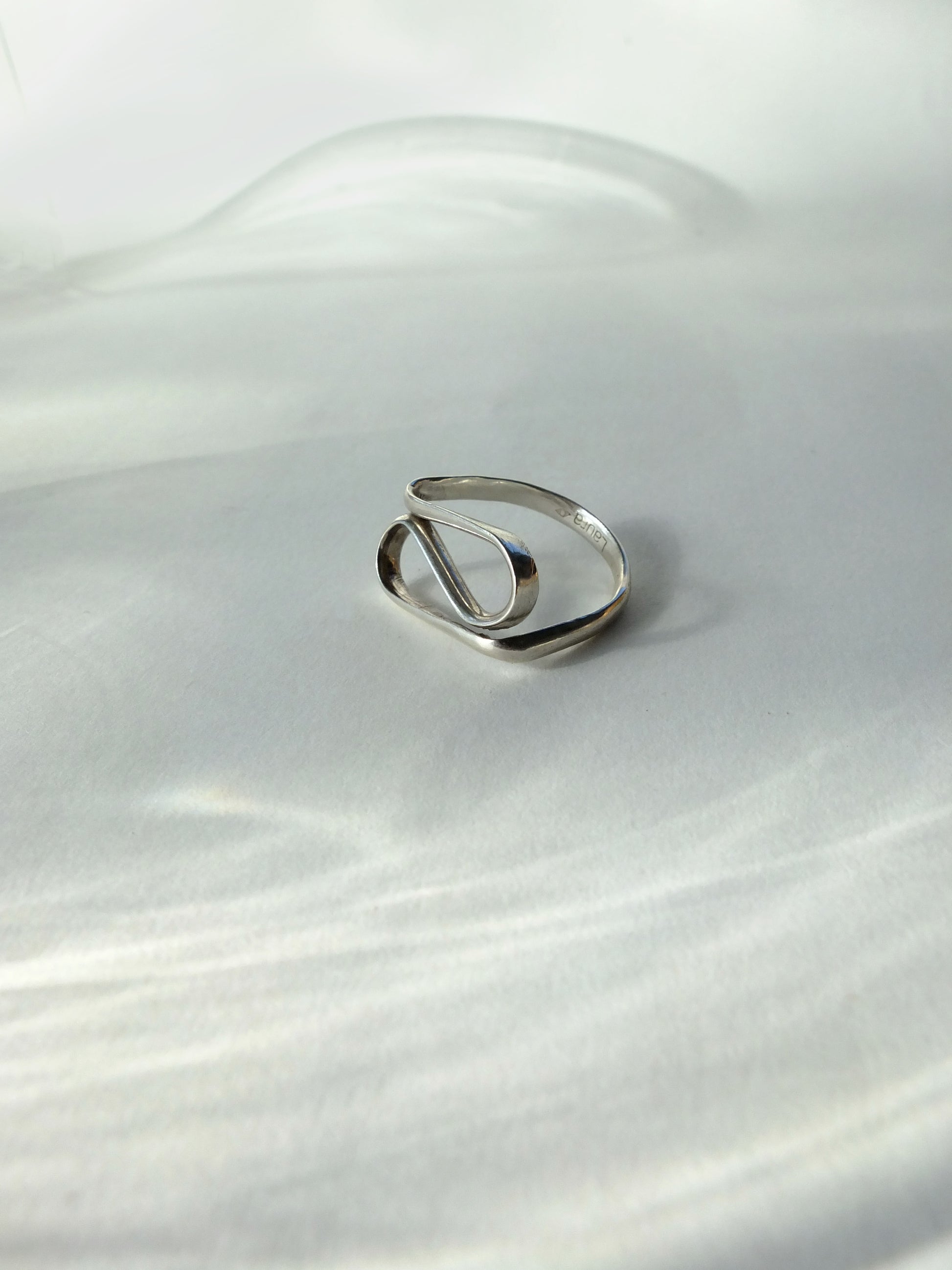 Silver ring on a white fabric background