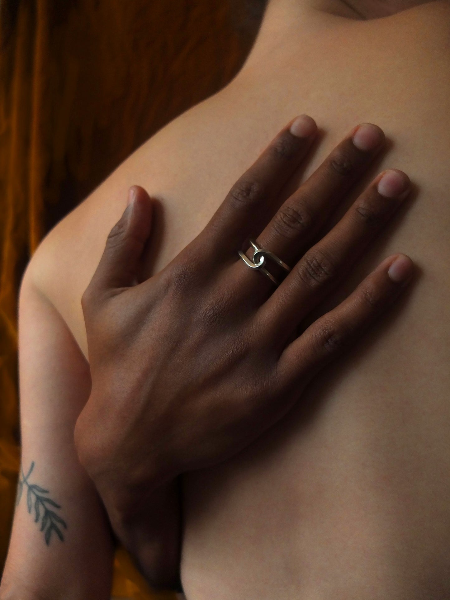 Hand with a ring on a person's chest against a blurred background