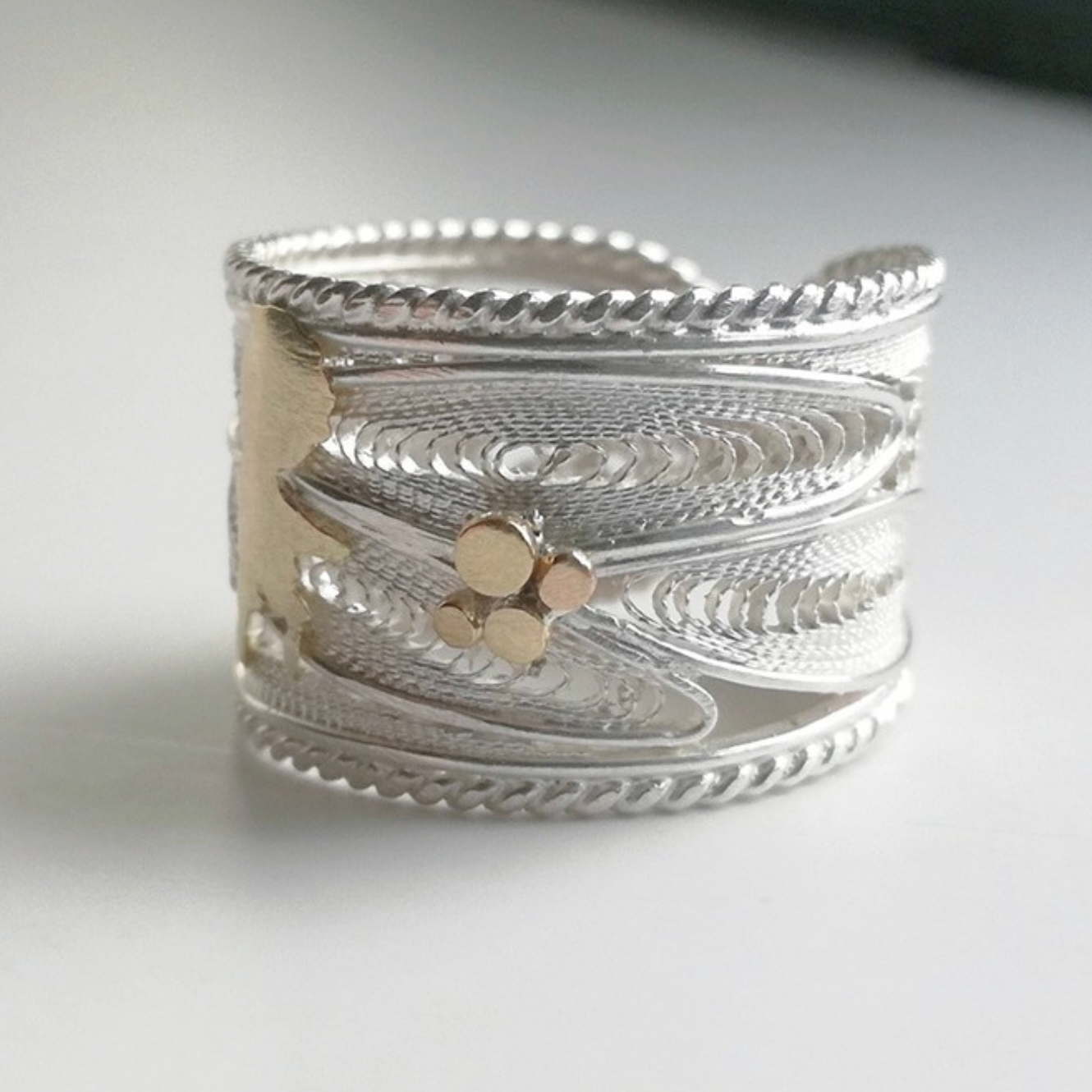 Silver ring with a textured design on a white background