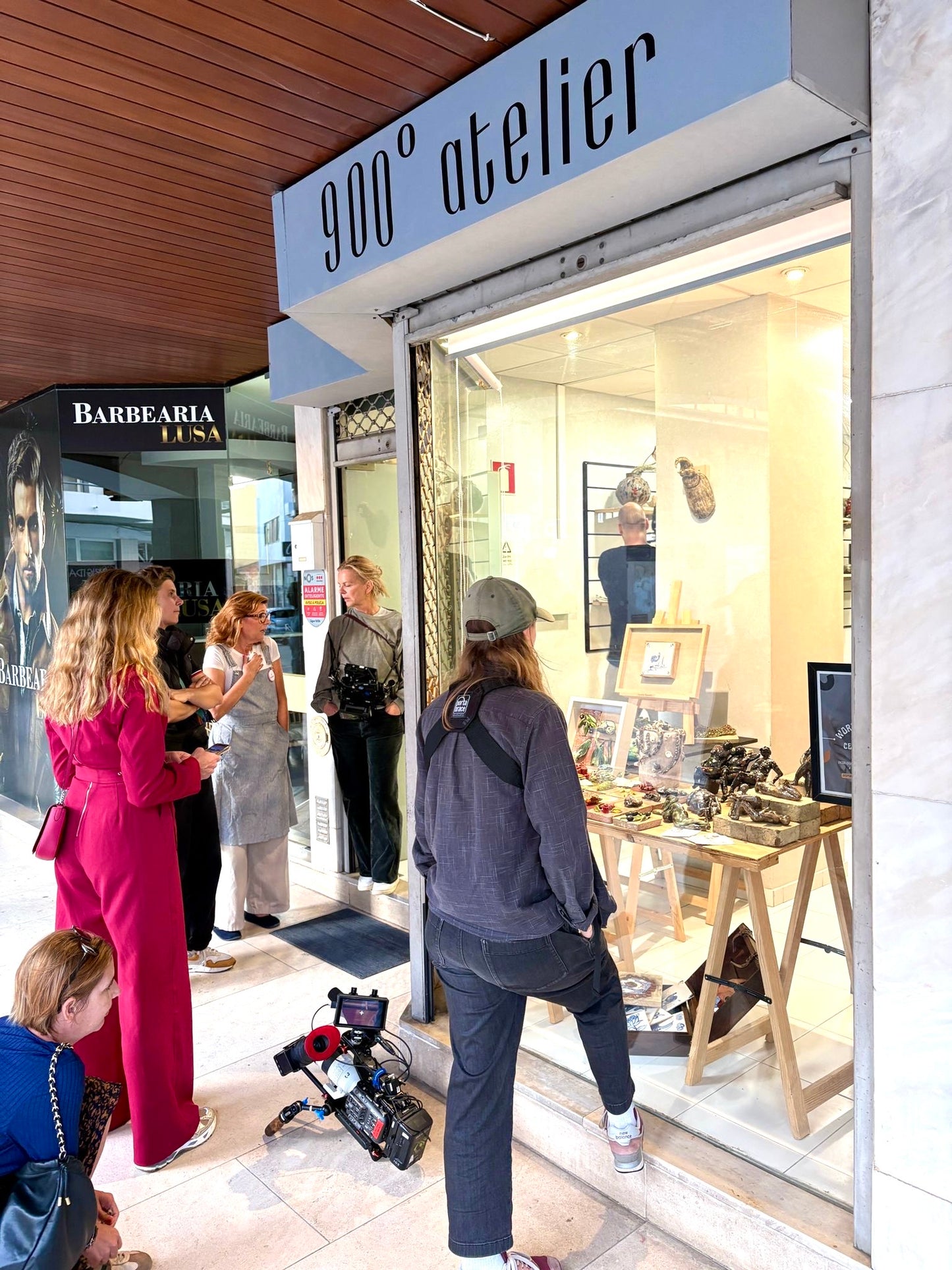 People outside a store with '900 atelier' sign, showing a casual shopping scene.