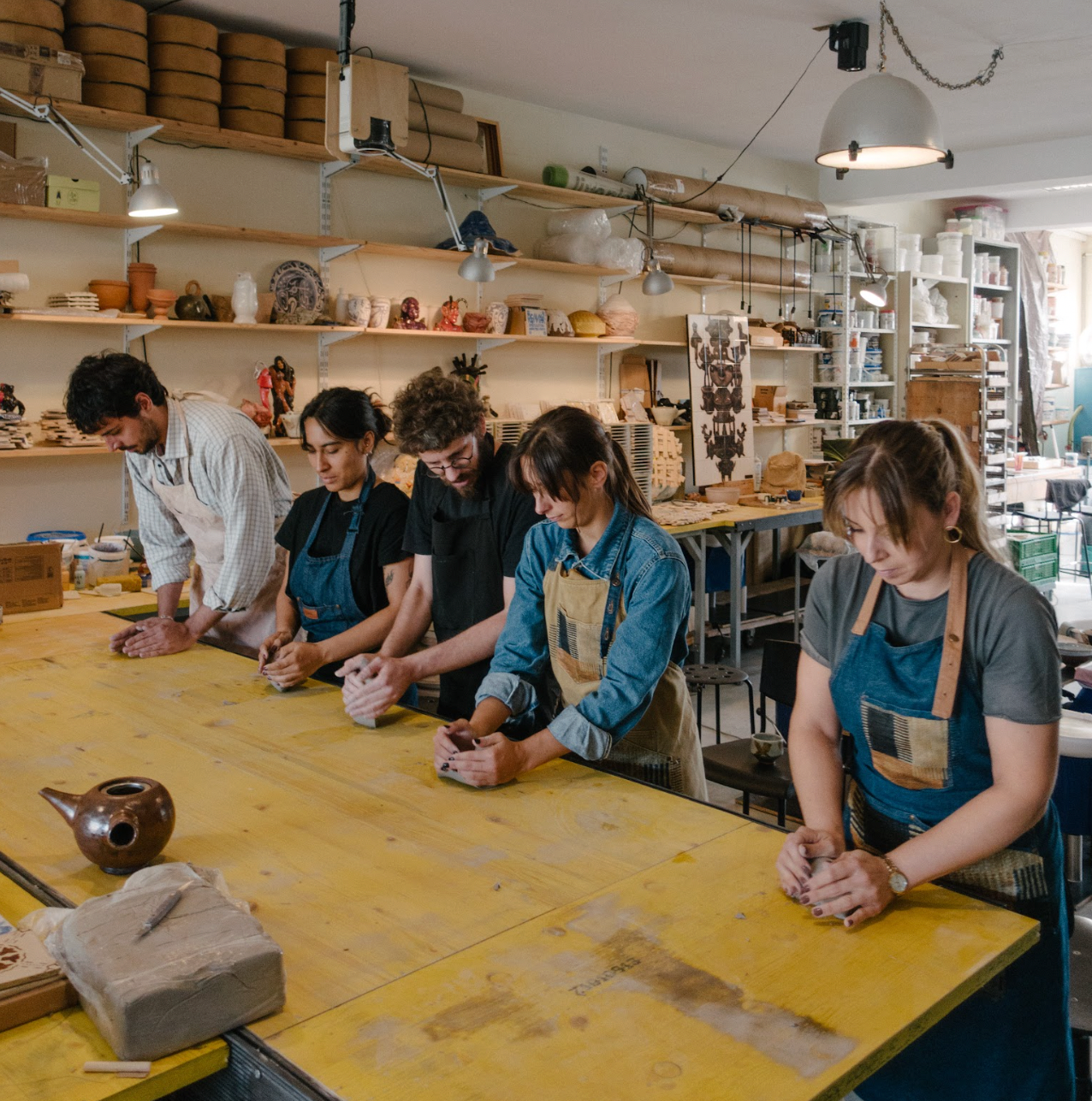 Group of people working on pottery in a workshop.