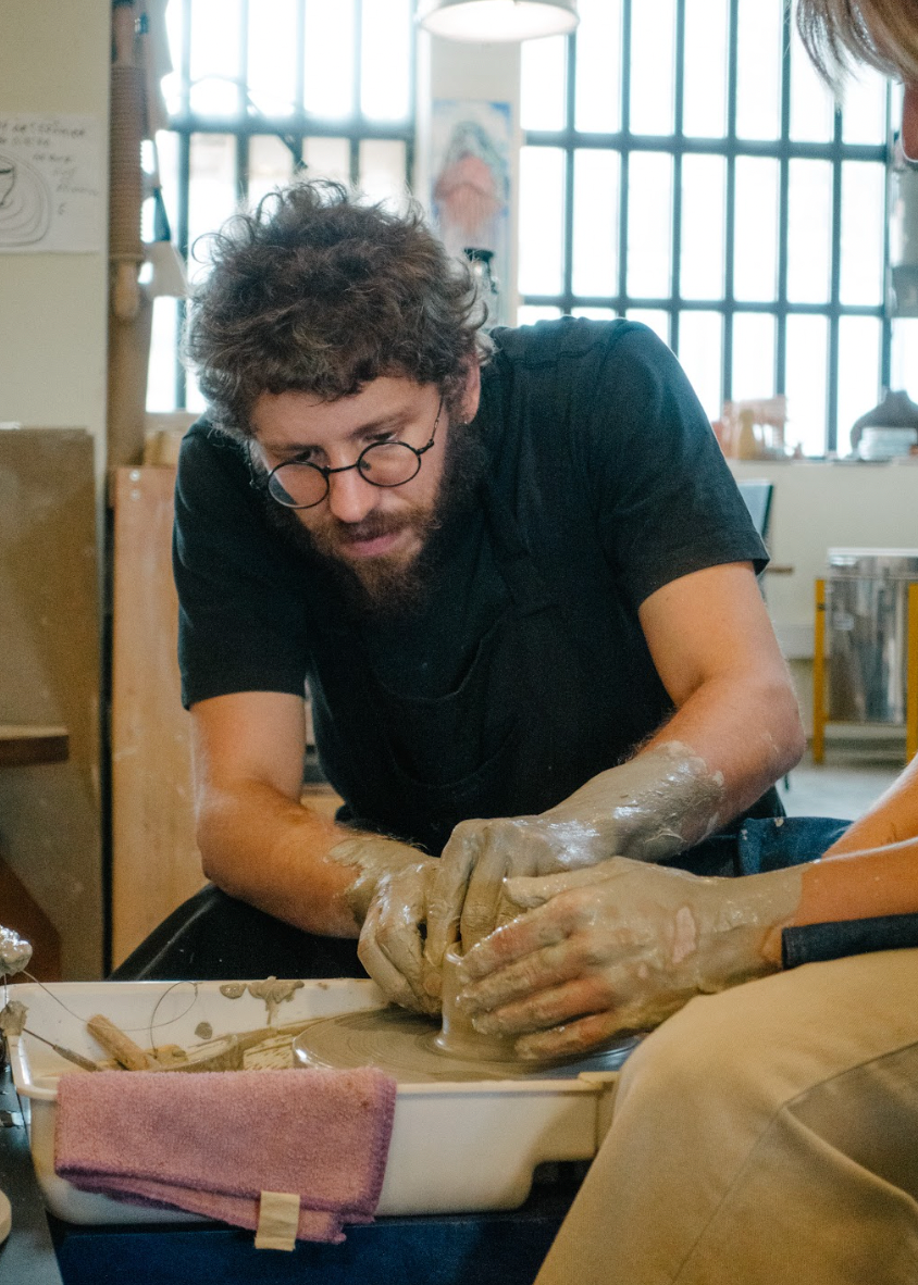 Person working with clay in a pottery studio