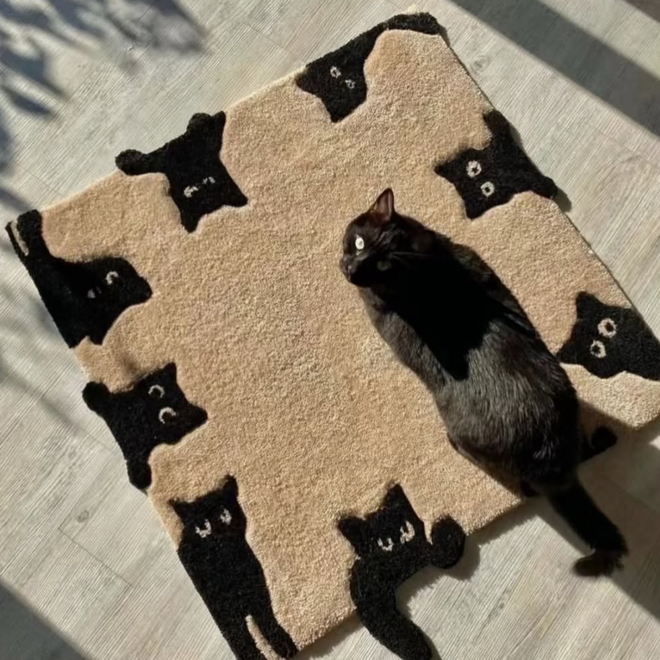 Black cat lying on a beige rug with black cat patterns