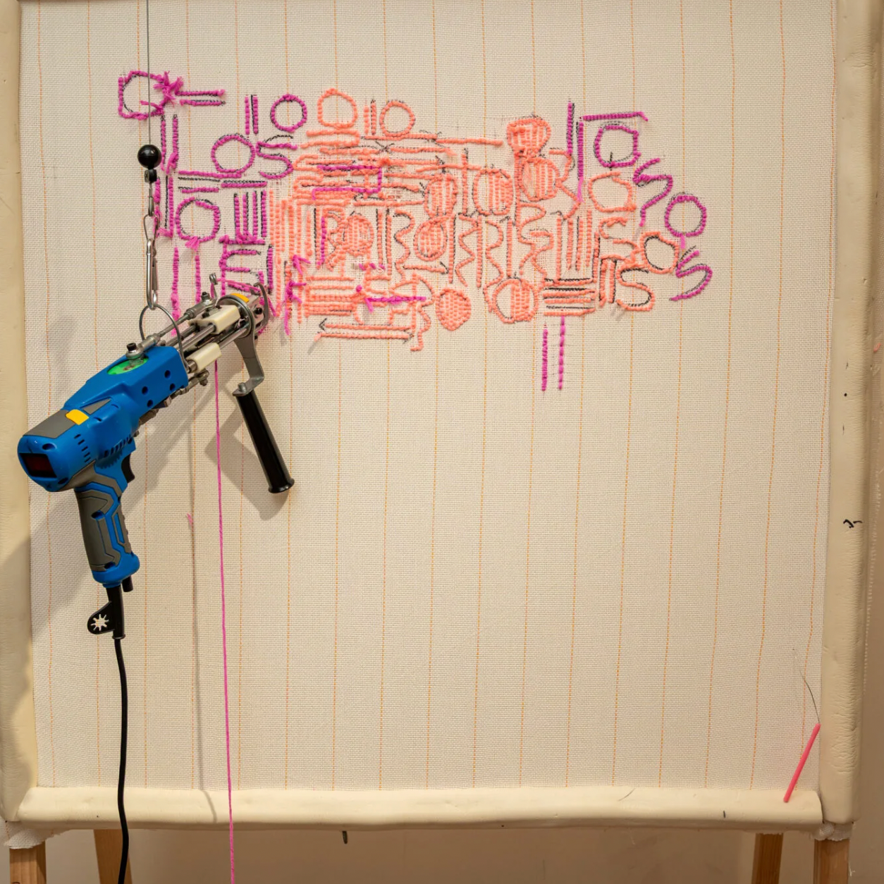Blue hot glue gun on a white board with colorful text art