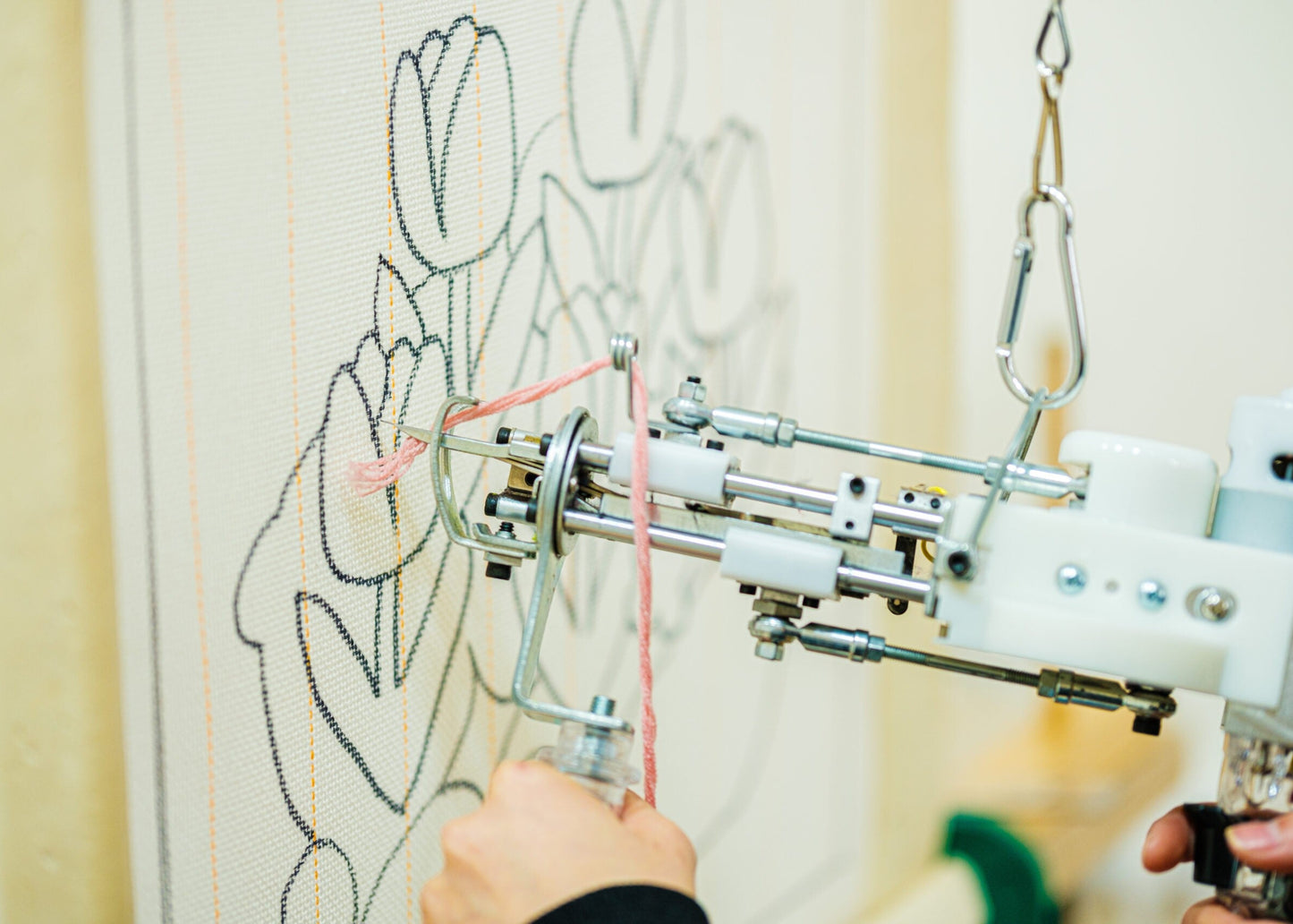 Embroidery machine stitching a floral design on fabric.