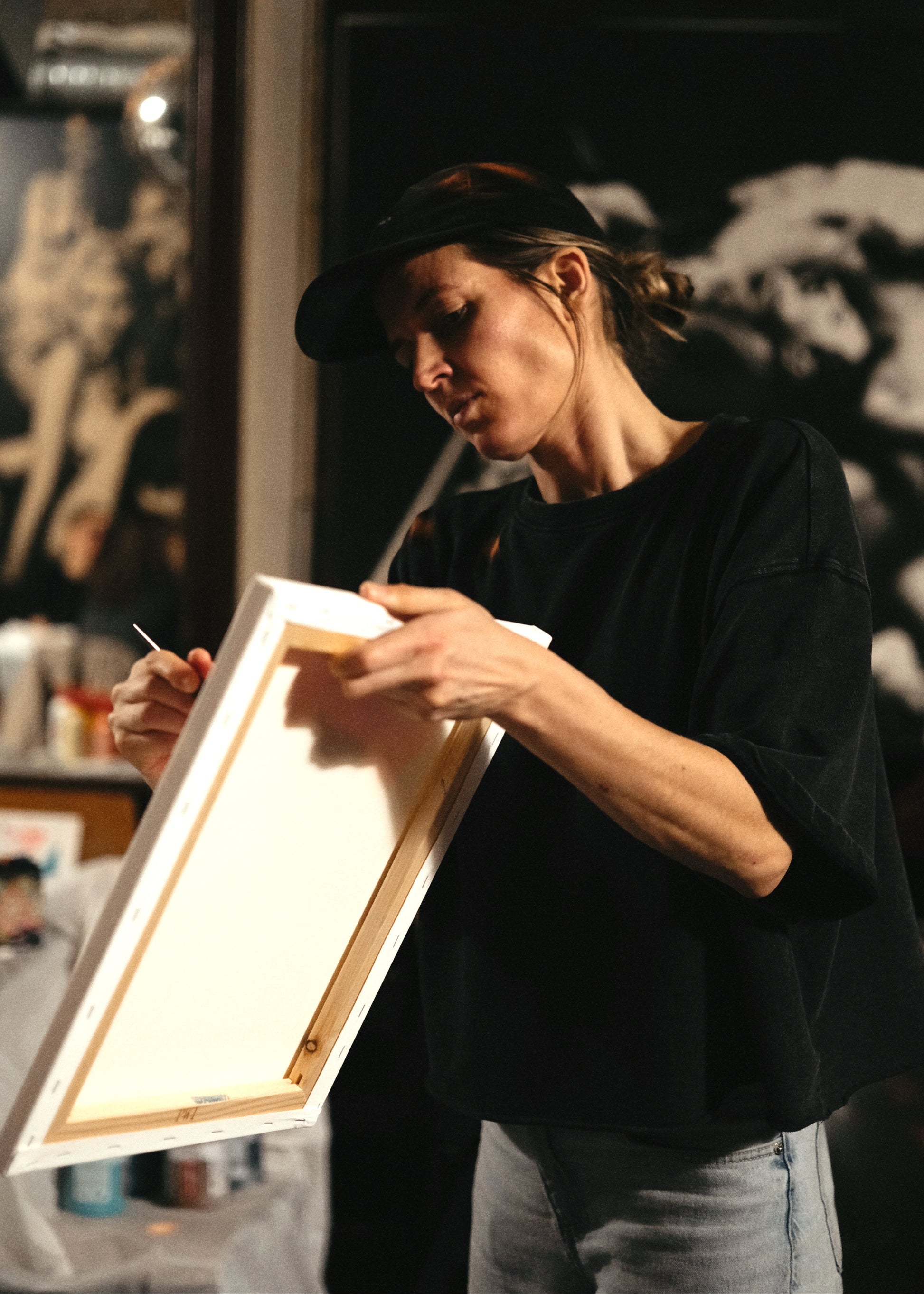 Person holding a framed artwork in a dimly lit room