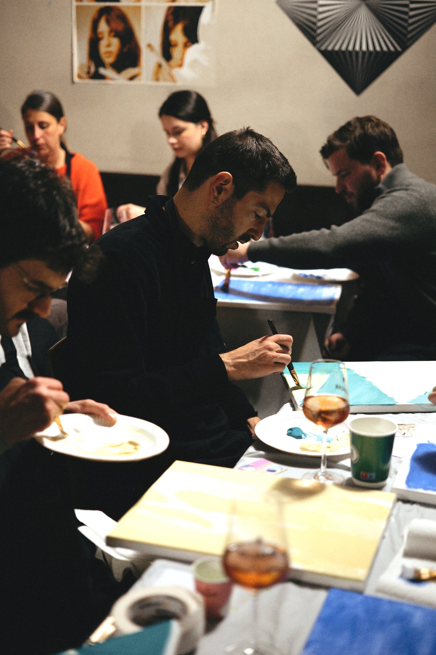 People dining at a table with drinks and plates in a restaurant setting.
