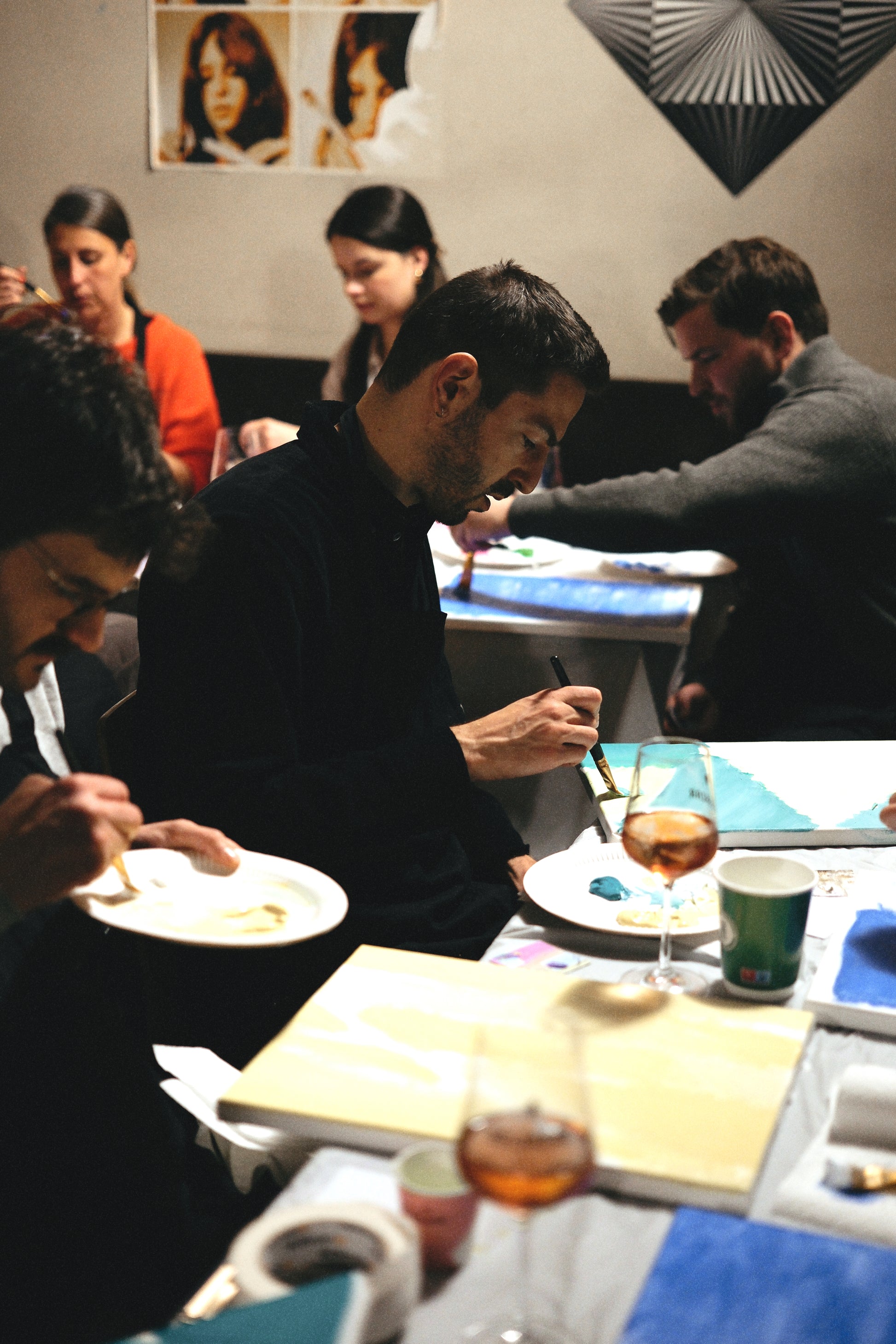 People dining at a table with drinks and plates in a restaurant setting.