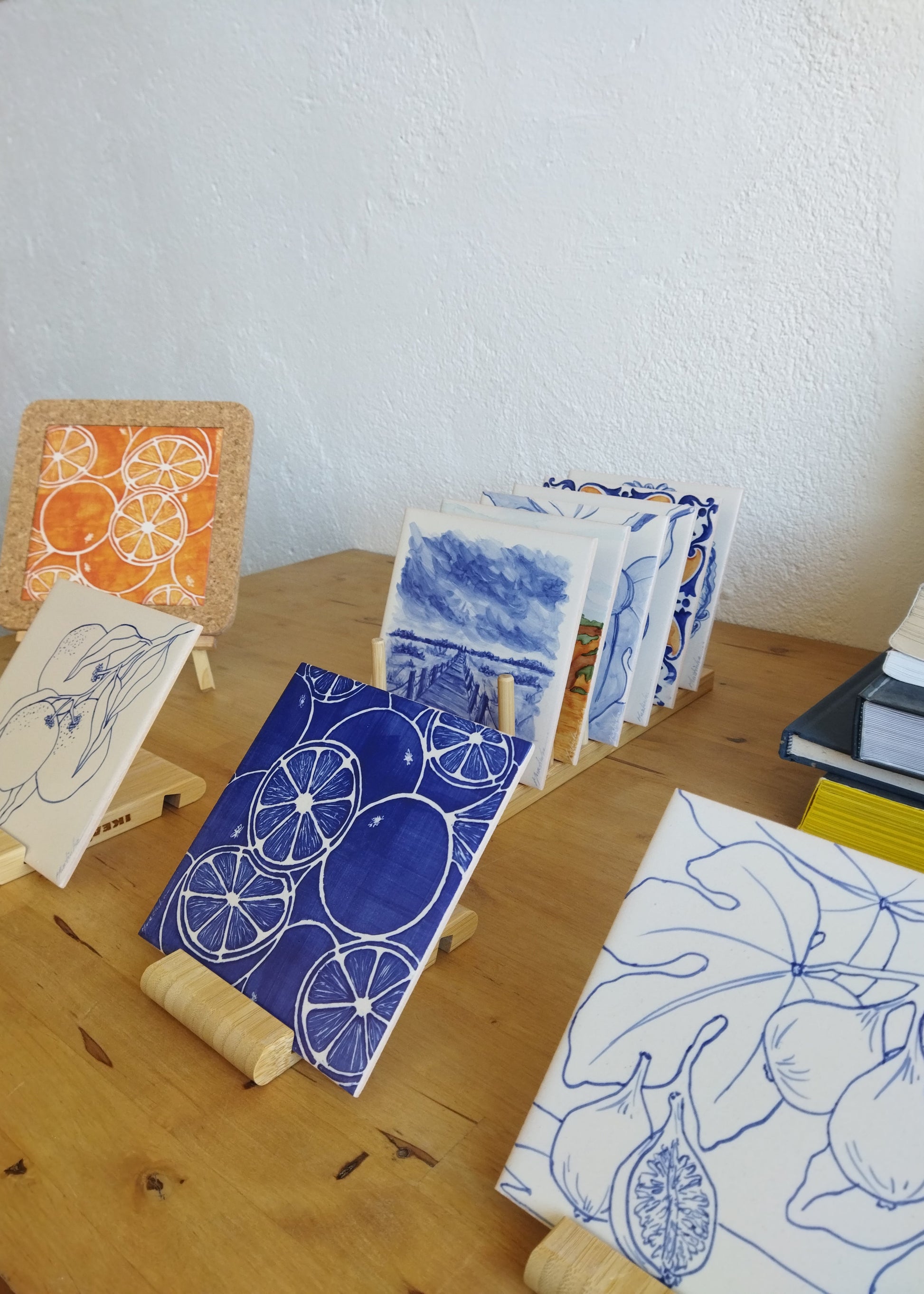 Collection of ceramic tiles with artistic designs on a wooden surface.