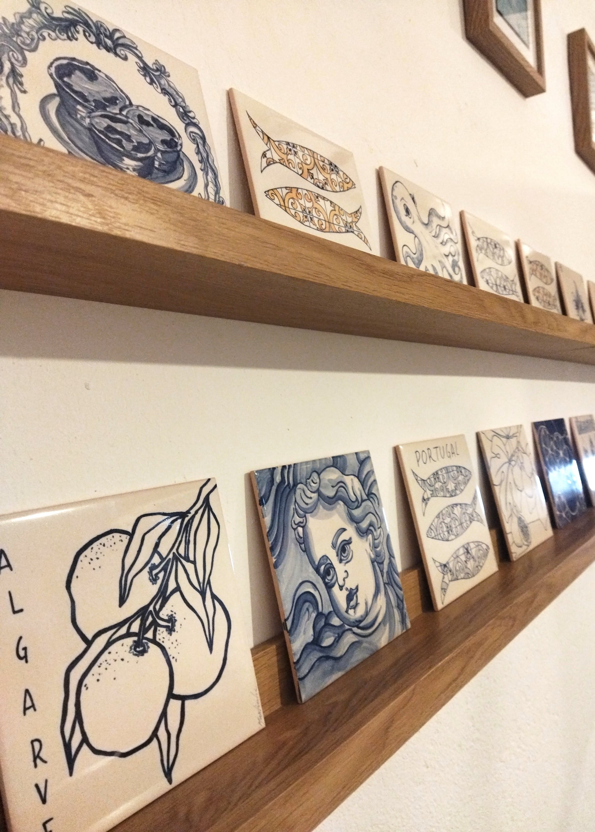 Decorative tiles on wooden shelves against a white wall