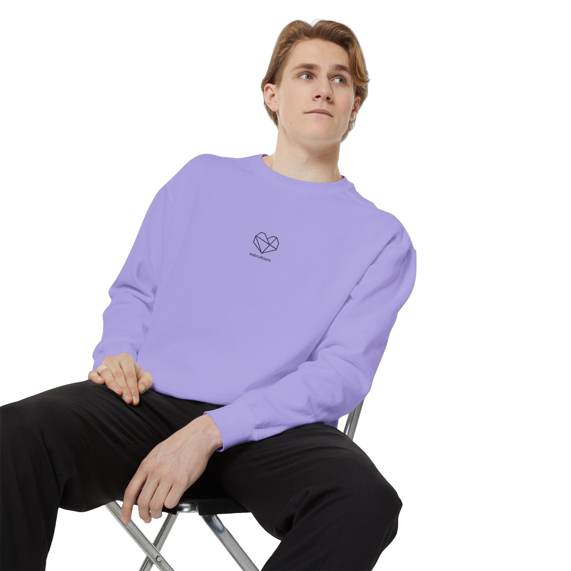 Person wearing a light purple sweatshirt with a logo, sitting on a chair against a white background