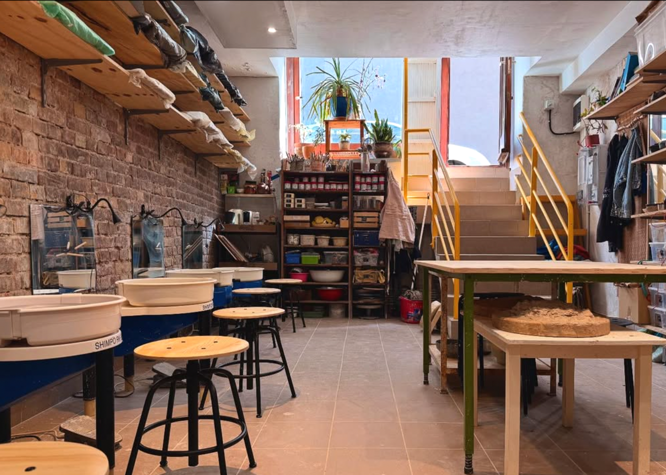 Workshop or studio with tables, stools, and shelves.