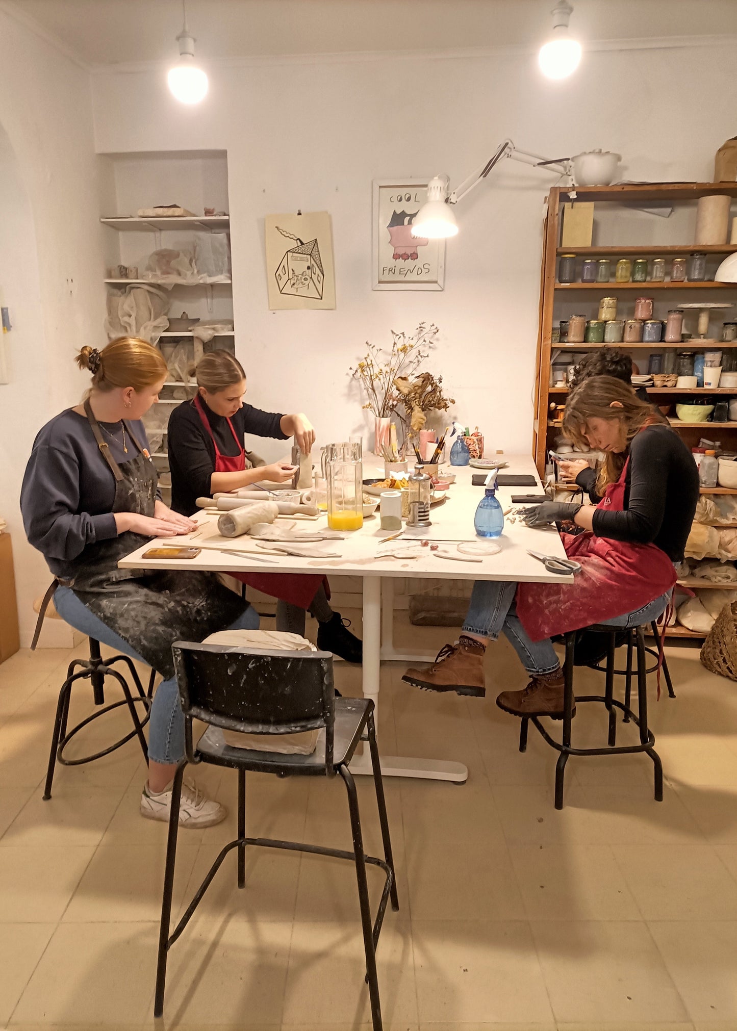 People sitting around a table in a cozy room with shelves and decor.
