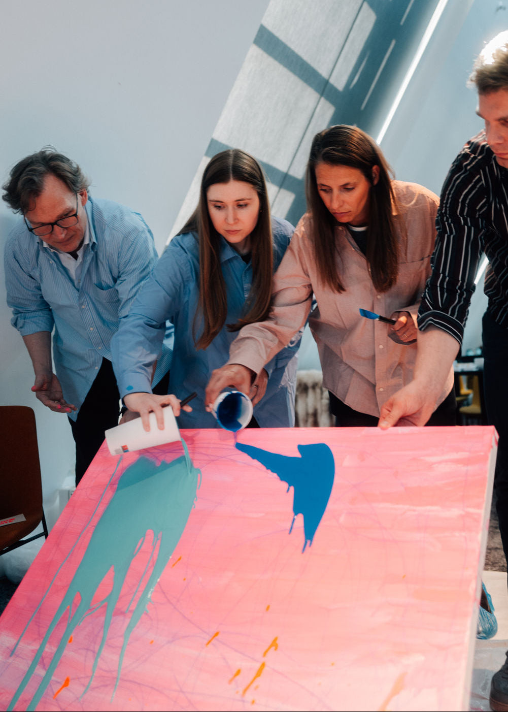 Group of people working on a painting project together.