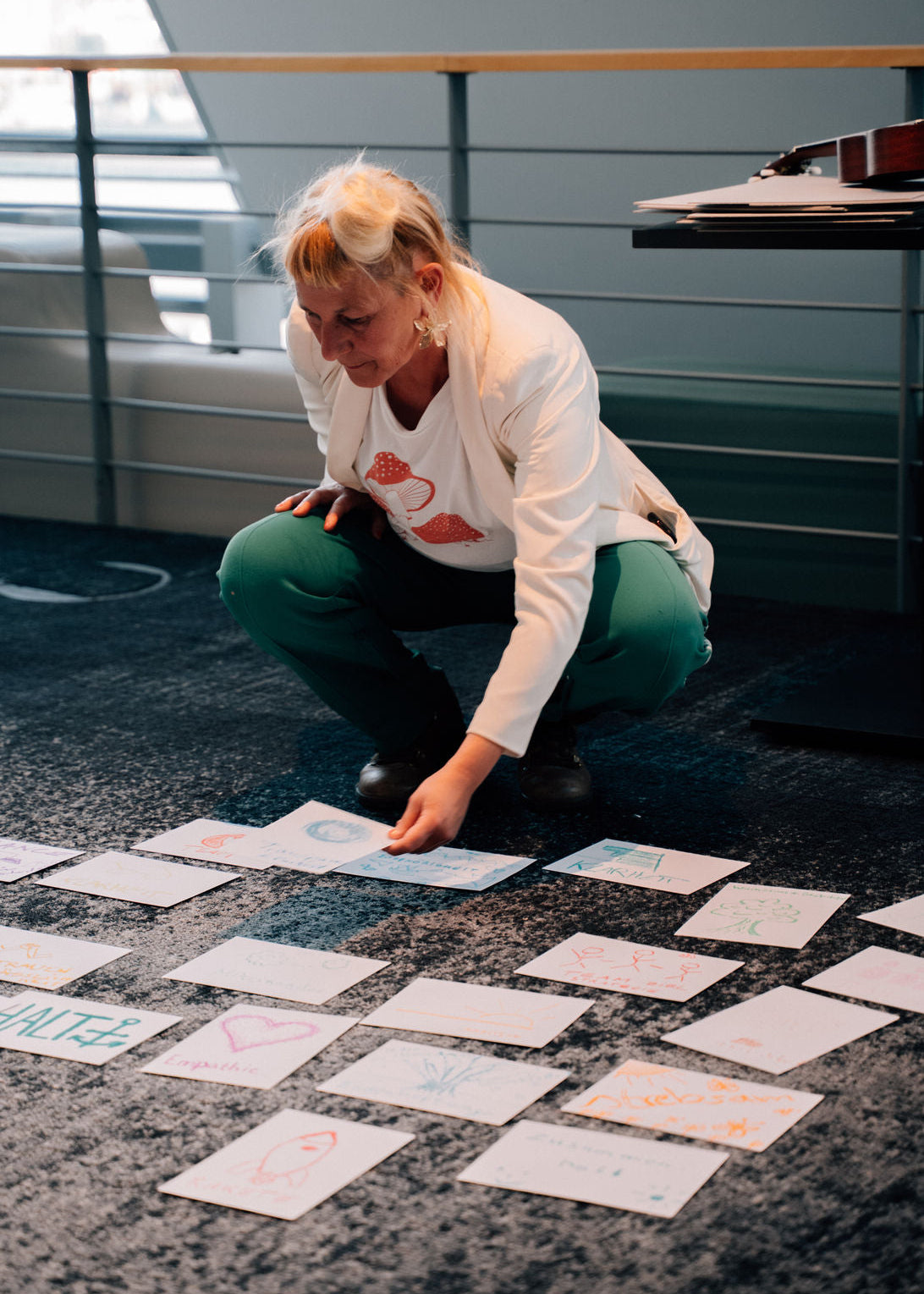 Person arranging cards on a floor with a modern interior background